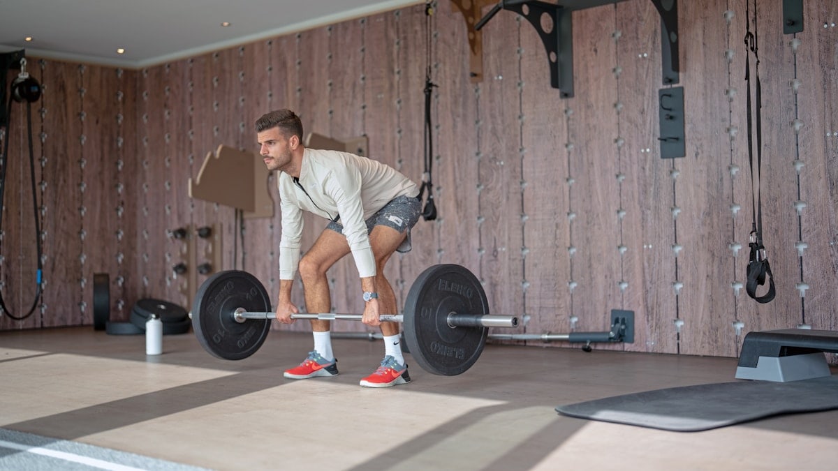 a man lifting a barbell in a gym